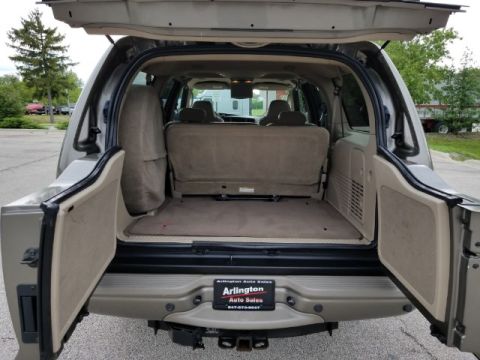2003 Ford Excursion - Rear view of a 2003 Ford Excursion's cargo space, showing folded seats and open rear doors.