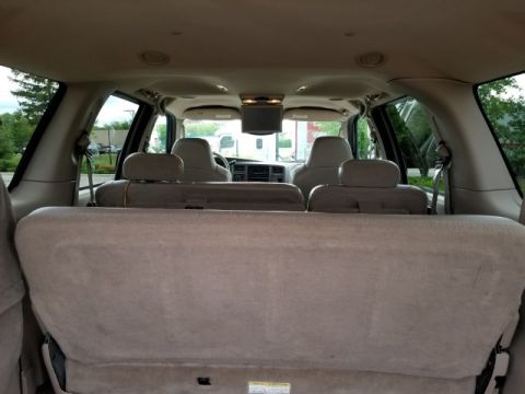 2003 Ford Excursion - Interior view of a large SUV, looking forward from the rear cargo area towards the front seats and dashboard.