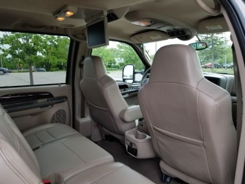2003 Ford Excursion - The spacious interior of a large SUV features multiple rows of seating and an overhead entertainment system.