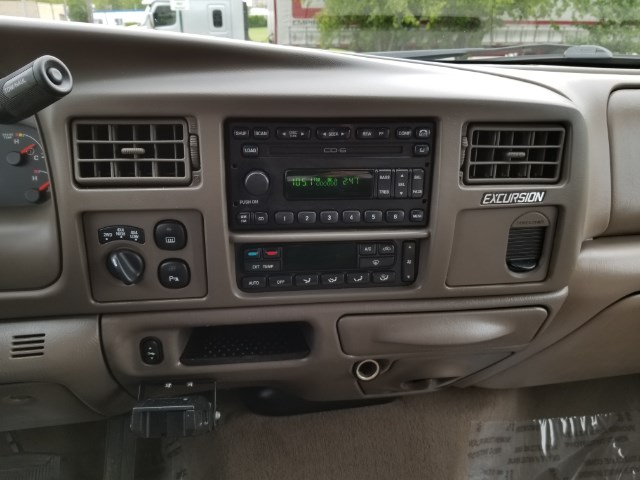 Tan center dash of a Ford Excursion with stacked radio and climate controls