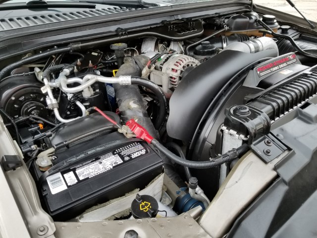 Engine bay with a large black air intake, battery, and radiator. Text on air intake reads "TURBO DIESEL"