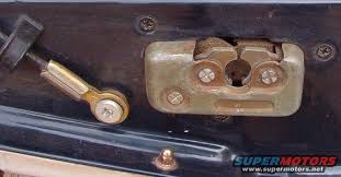 1994 Ford Bronco - Close-up photo of a tailgate latch mechanism and adjustable linkage rod mounted in a body panel.