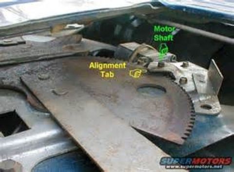 1994 Ford Bronco - Photo of a rusty window regulator sector gear with green callouts for the alignment tab and motor shaft.