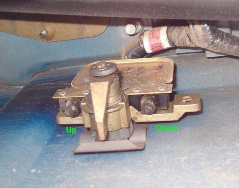 1994 Ford Bronco - Under-vehicle photo of a tailgate window latch actuator labeled Up and Down with a Ford wiring connector.