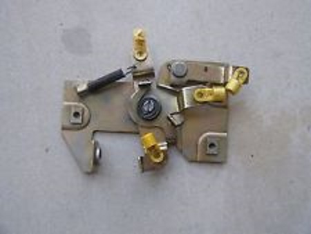 1994 Ford Bronco - Bench photo of a metal tailgate window switch and latch contact assembly with brass terminals.