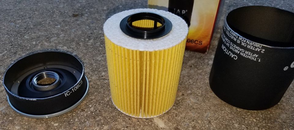 Yellow oil filter with black end cap on concrete