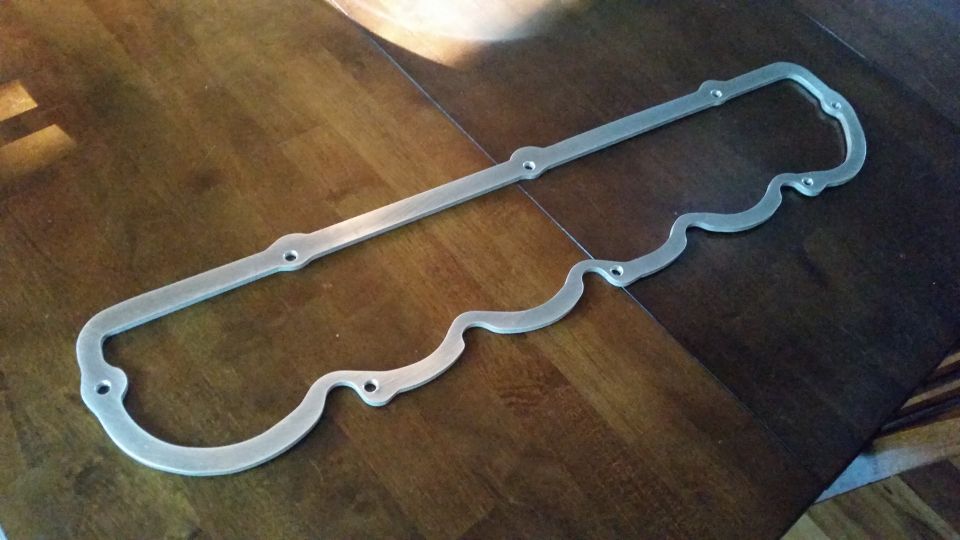 Silver metal valve cover gasket on a wooden table