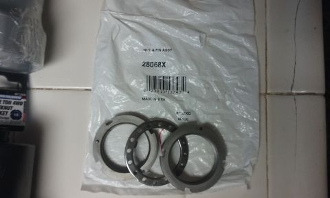 1995 Ford Bronco - A white plastic bag contains a nut and pin assembly labeled "28068X" and "MADE IN USA". Three metal rings are visible beneath the bag.