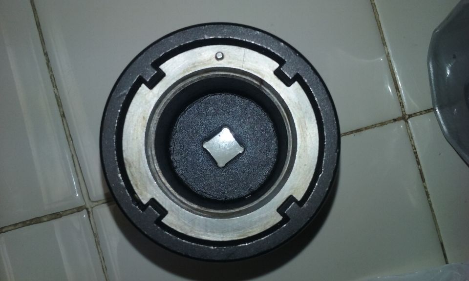 Close-up of a socket wrench adapter with a square drive opening.