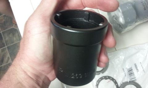 1995 Ford Bronco - A hand holds a black metal socket wrench attachment with markings that include "M.259". In the background, a plastic-wrapped automotive par…