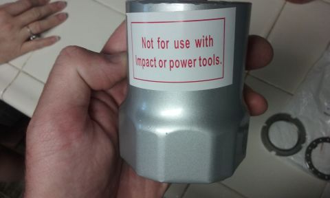 1995 Ford Bronco - A hand holds a silver-colored tool with a red and white label that reads "Not for use with Impact or power tools.".