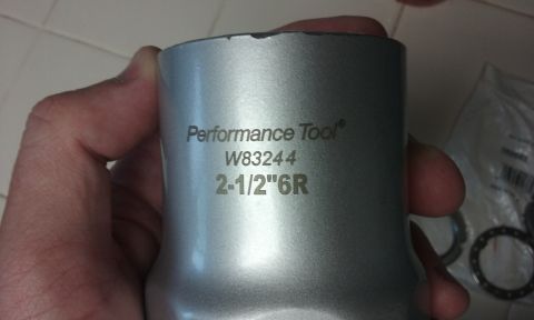 1995 Ford Bronco - A hand holds a silver metal tool with engraved text that reads "Performance Tool® W83244 2-1/2"6R".