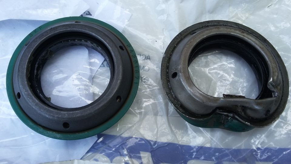 Two automotive seals, one green and one damaged, with visible part numbers.