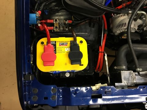 1996 Ford Bronco - The engine bay of a 1996 Ford Bronco shows a bright yellow Optima battery with red and black terminal covers, connected to various red cabl…