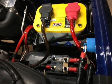 1996 Ford Bronco - A close-up view of a vehicle's engine bay shows a yellow Optima battery with red and black terminal covers. A blue relay and a fuse block a…