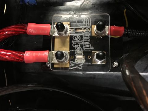 1996 Ford Bronco - A close-up view shows a SoundKranx brand fuse holder with two red power cables connected to it. The fuse holder is mounted on a black surfa…