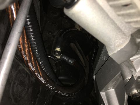 1996 Ford Bronco - A close-up view shows thick copper wiring protected by black corrugated tubing. Text on the wire reads "STANDARD 0 GAUGE PRIMARY WIRE PW-0-…