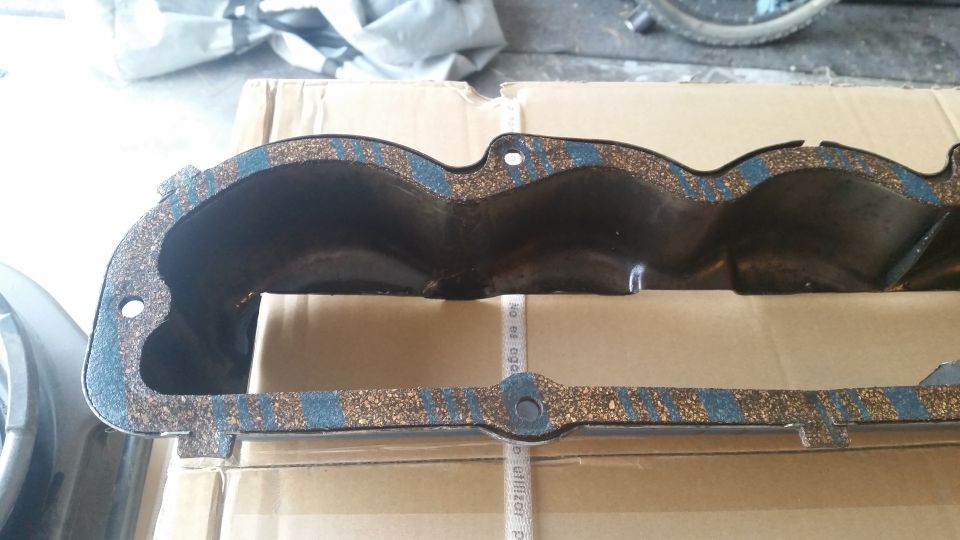 Black valve cover gasket with cork and blue stripes.