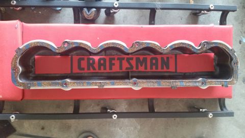 1981 Ford Bronco - A valve cover gasket with the word "CRAFTSMAN" visible on a red insert is shown from a top-down perspective, resting on a red mat and black…