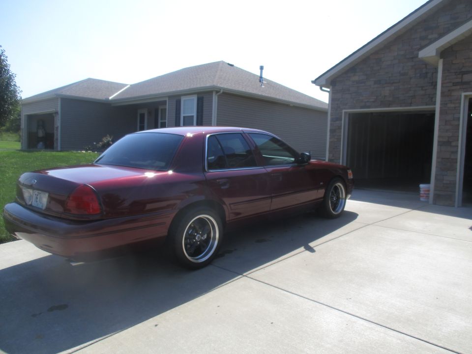 Dark red sedan parked on a concrete driveway.