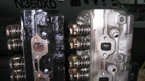 1996 Ford Bronco - Two engine cylinder heads are shown side-by-side, one is black and appears older, while the other is silver and looks newer. Both have visi…