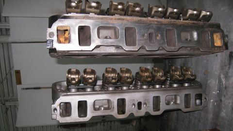 1996 Ford Bronco - Two Ford V8 engine cylinder heads are shown, one stacked above the other. The top cylinder head appears to be older and shows signs of rust…