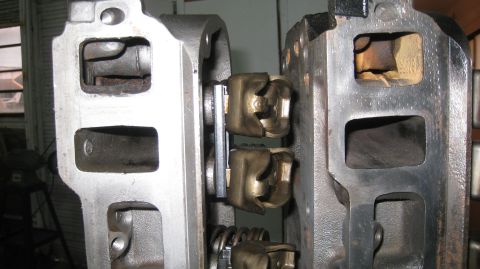 1996 Ford Bronco - A close-up view shows two engine cylinder heads with rocker arms and valve springs visible. The metal parts are gray and appear to be part…