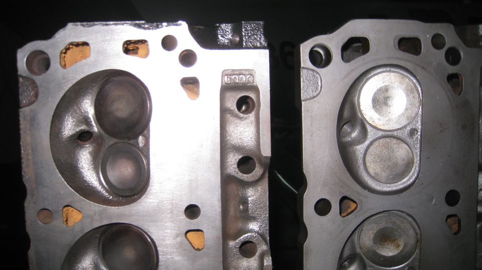 Two cast iron cylinder heads with visible ports and valves.