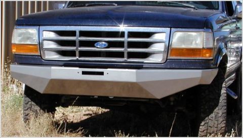 1996 Ford Bronco - Front view of a dark blue Ford Bronco with an aftermarket silver bumper. The vehicle has a chrome grille with the Ford logo visible.