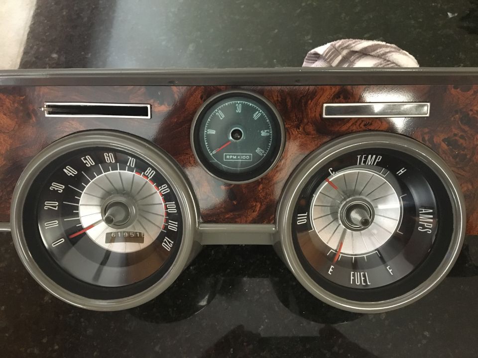 Vintage car dashboard with speedometer, tachometer, fuel, temp, and amp gauges.