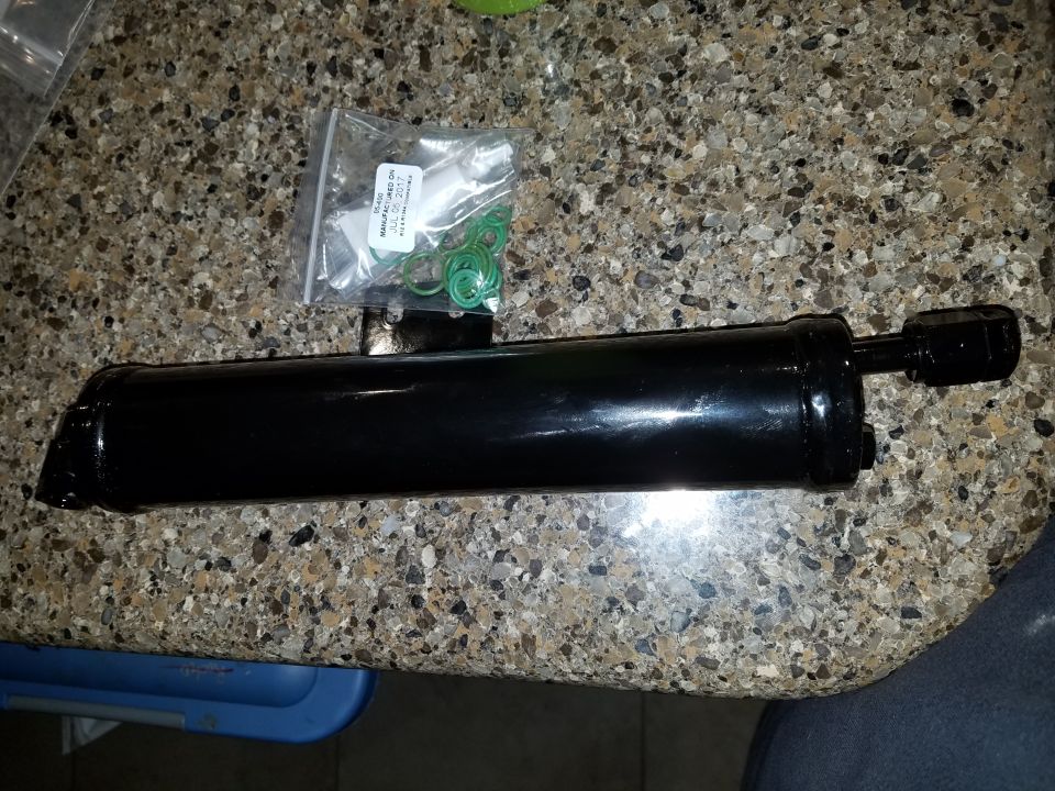 Black receiver/drier assembly with O-rings and cap on a speckled countertop.