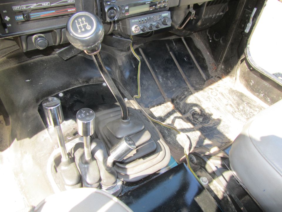 Interior of a Jeep YJ showing the center console with shifters and dashboard.