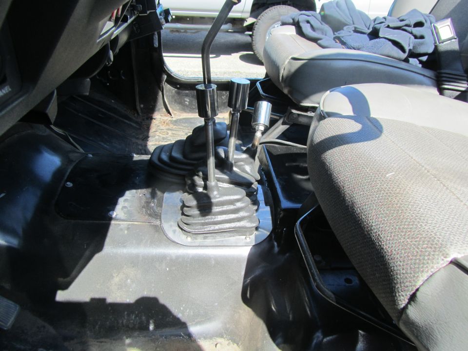 Interior of a Jeep YJ showing the floor, shifters, and passenger seat.
