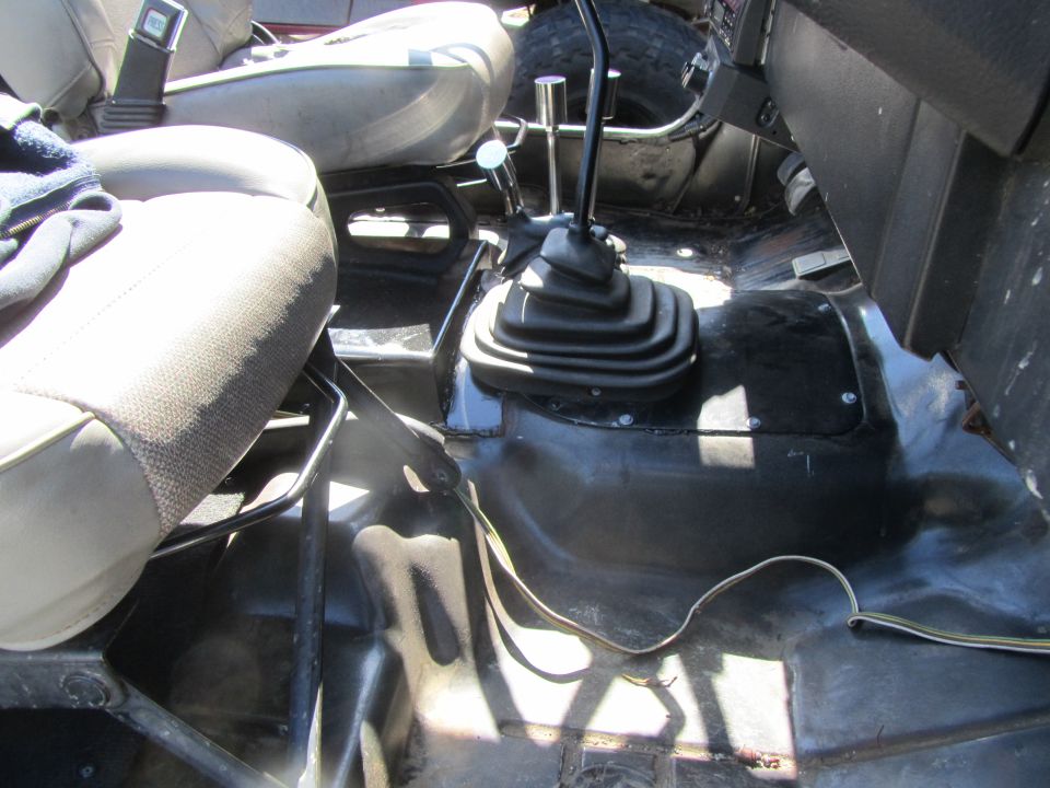 Interior of a Jeep YJ showing seats, shifter, and floor.
