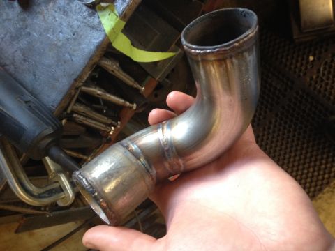 1997 Ford F-350 - A custom exhaust pipe, likely for a vehicle modification, is shown being held. The welds are clearly visible.