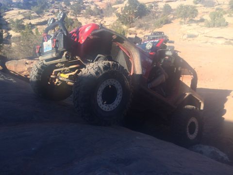 1995 Jeep Wrangler - A red Jeep YJ is navigating a rocky, off-road trail with large, aggressive tires. The vehicle is angled upwards, showing its suspension and…