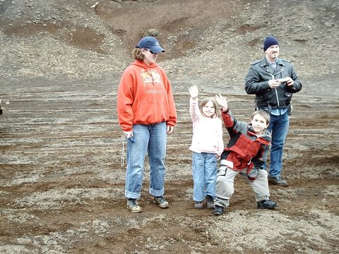 1996 Ford Bronco - A group of people wave while standing in a rocky, barren landscape.
