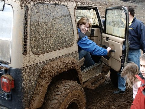 1996 Ford Bronco - People pose with a heavily mud-splattered Jeep Wrangler during an off-road excursion.