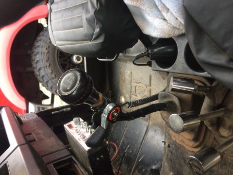 1995 Jeep Wrangler - Interior view of a manual transmission shifter and a CB radio mounted in a vehicle. A spare tire is visible through the open door.