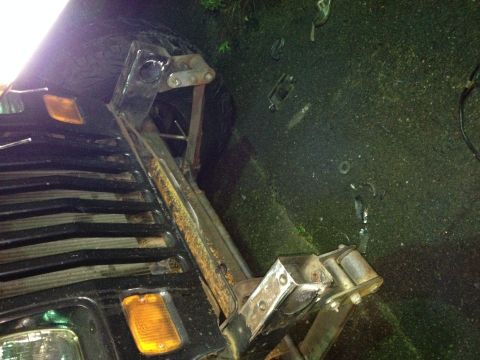 1995 Jeep Wrangler - The image shows the rear passenger side of a black Jeep YJ with a custom metal fabrication attached to the bed. The fabrication appears to…