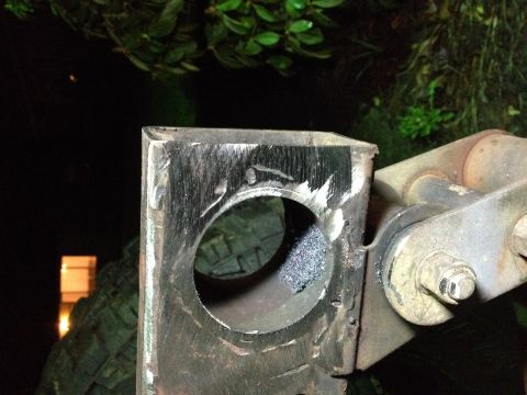 1995 Jeep Wrangler - A close-up view of a metal bracket with a circular cutout, showing signs of grinding and welding. A bolt and part of another metal componen…