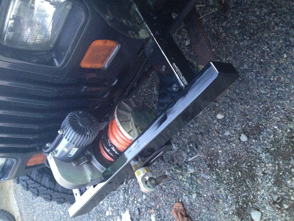 Close-up of a winch and bumper on a dark vehicle.
