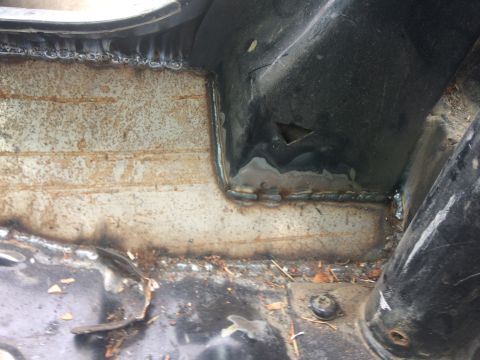 1995 Jeep Wrangler - This is a close-up shot of a vehicle's undercarriage, showing recent welding work on what appears to be a frame repair. The metal is rough…