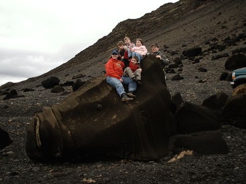 1996 Ford Bronco - Family poses on a large rock formation in a rocky, barren landscape with a vehicle nearby.