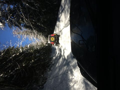 1995 Jeep Wrangler - Off-road vehicle navigating a snow-covered path with trees lining the side.