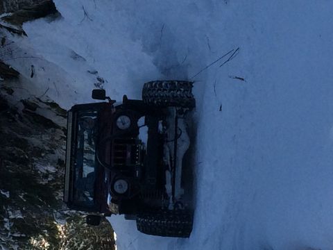 1995 Jeep Wrangler - A Jeep lies on its side in a snowy landscape, likely after an off-road incident.