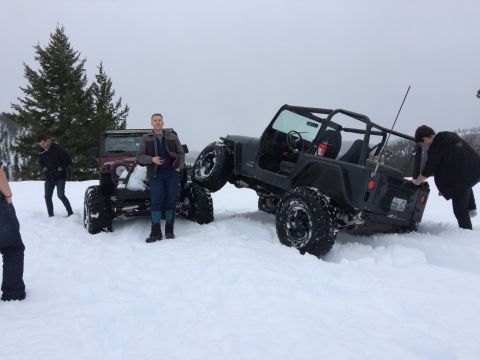 1995 Jeep Wrangler - Two Jeeps navigate a snowy terrain, with one prominently displaying its off-road capabilities.