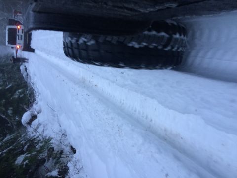 1995 Jeep Wrangler - A Jeep YJ navigates a snow-covered road, its spare tire visible.