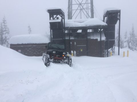 1995 Jeep Wrangler - A Jeep Wrangler navigates a snowy path towards a snow-covered structure with a large tower.