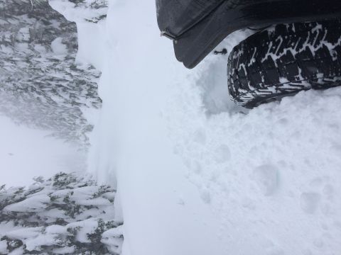 1995 Jeep Wrangler - A Jeep tire navigates through deep snow, suggesting off-road adventure in winter conditions.